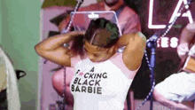 a woman is wearing a t-shirt that says a fucking black barbie