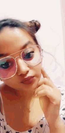 a woman wearing sunglasses and a necklace is making a face
