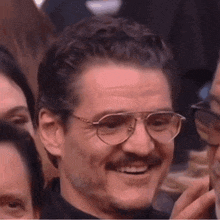 a close up of a man wearing glasses and a mustache .