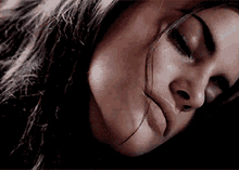 a close up of a woman 's face with her eyes closed and her mouth open .
