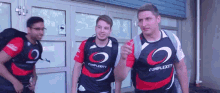 a group of men wearing complexity shirts are standing outside of a building