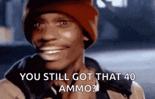 a man wearing a red beanie is smiling and saying you still got that 40 ammo .