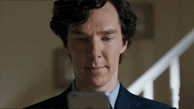 a man in a suit and tie is looking at his phone