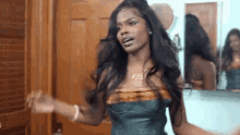 a woman with long hair is standing in front of a mirror .