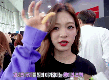 a woman in a purple sweatshirt is holding a yellow object in her hand