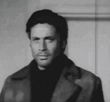 a black and white photo of a man in a fur coat