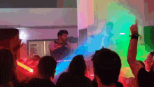 a man playing a guitar in front of a crowd with their arms in the air