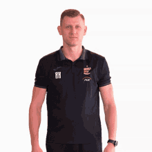 a man wearing a black polo shirt with the letters rh on the front