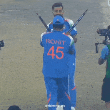 a man is taking a picture of two cricket players one of whom has the number 4 on his shirt
