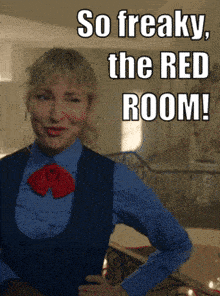 a woman in a blue shirt and vest stands in front of a sign that says " so freaky the red room "