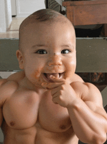 a baby with muscles on his chest is smiling and eating something