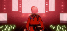 a man in a red jacket is standing on a stage in front of a crowd .