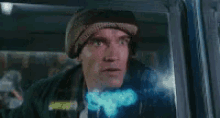 a man with a bandage on his head is looking out of a car window and says shit .