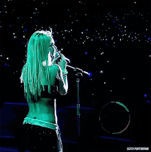 a woman with green hair singing into a microphone with the words edits portiranoni written on the bottom