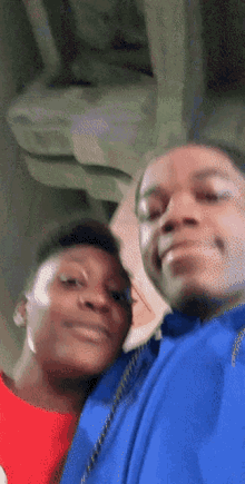 two young men are posing for a picture and one is wearing a blue jacket