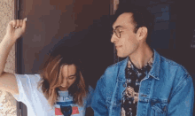 a man in a denim jacket and a woman in a white shirt