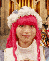 a woman with pink hair is wearing a white hat with horns