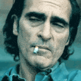 a man is smoking a cigarette with a cigarette in his mouth .