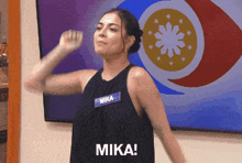a woman in a black tank top with the name mika on it