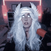 a woman wearing a wig with wings on her head