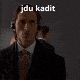a man in a suit and tie is wearing a headset with the word jdu kadit written above him