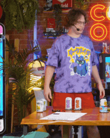 a man wearing a tie dye t-shirt with a cat on it
