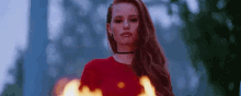 a woman is standing in front of a fire .