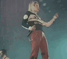 a woman is singing into a microphone on stage .
