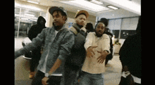 a group of young men are dancing together in a room