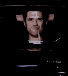a man is screaming in a dark room while holding a remote control .