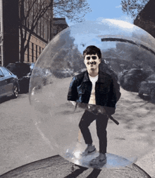 a man is standing inside of a clear bubble on a city street