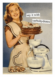 a woman is holding a cake in front of a mixer and a mixer .