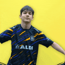 a boy wearing a black and yellow shirt with aldi on it