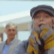 a woman wearing a hat and gloves is screaming