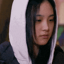 a close up of a woman wearing a white hood