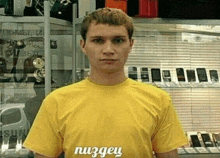 a man wearing a yellow shirt that says nuzgen on it