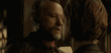 a man with a beard is hugging a younger man