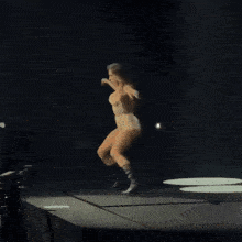a woman is dancing on a stage with a microphone in her hand