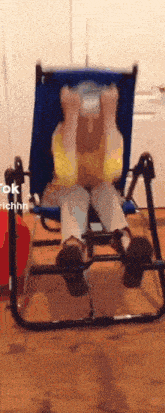 a person is sitting in a chair with their legs crossed and their head down .