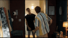 a man in a striped shirt is standing next to another man