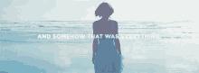 a woman in a blue dress is standing on a beach with the words `` and somehow that was everything '' above her .
