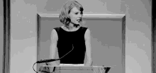 taylor swift is standing at a podium giving a speech .