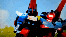 a red and blue robot with the letter t on its chest