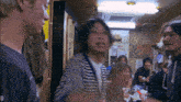 a group of people are gathered in a room with a kirin sign on the wall