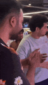 a group of men are standing next to each other holding hands in a room .