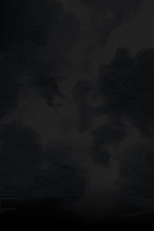 a dark cloudy sky with a few trees in the foreground .