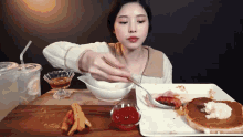 a woman is eating a plate of food with a spoon