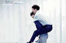 a man is carrying another man on his back while another man watches .