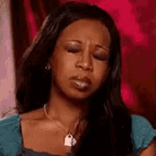 a woman is making a funny face with her eyes closed and her mouth open .
