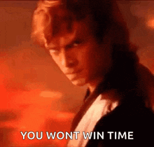 a man in a tuxedo is standing in front of a red background and says `` you wont win time '' .